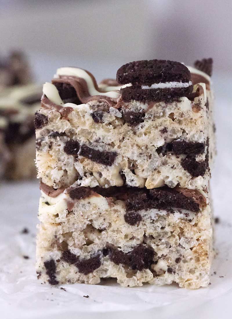 two squares of oreo rice krispie treats stacked on a white table.