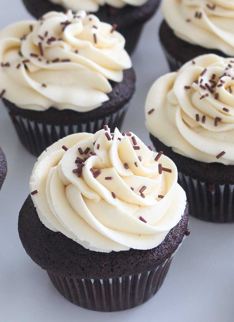 chocolate cupcakes with a swirl of white frosting and chocolate sprinkles