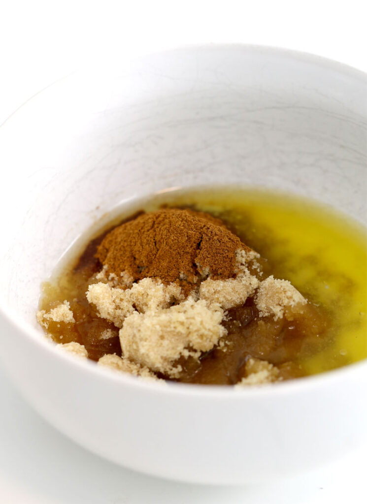 A white bowl containing brown sugar, butter and ground cinnamon. This is the base of the cinnamon swirl drizzle.