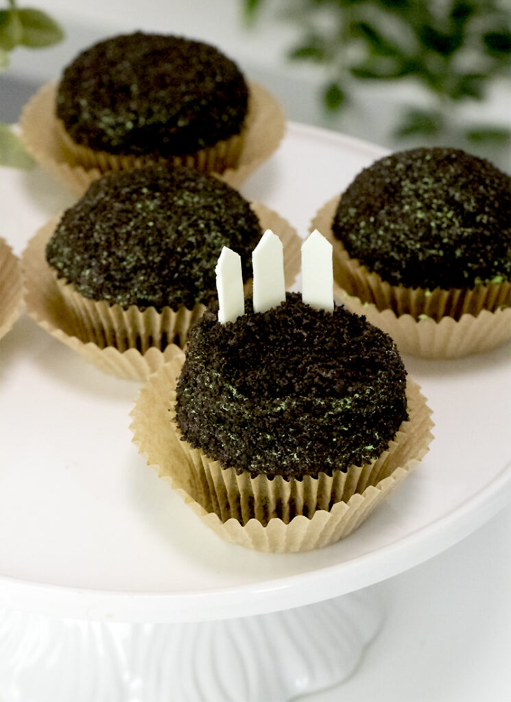 stick the chocolate fencing onto the cupcakes