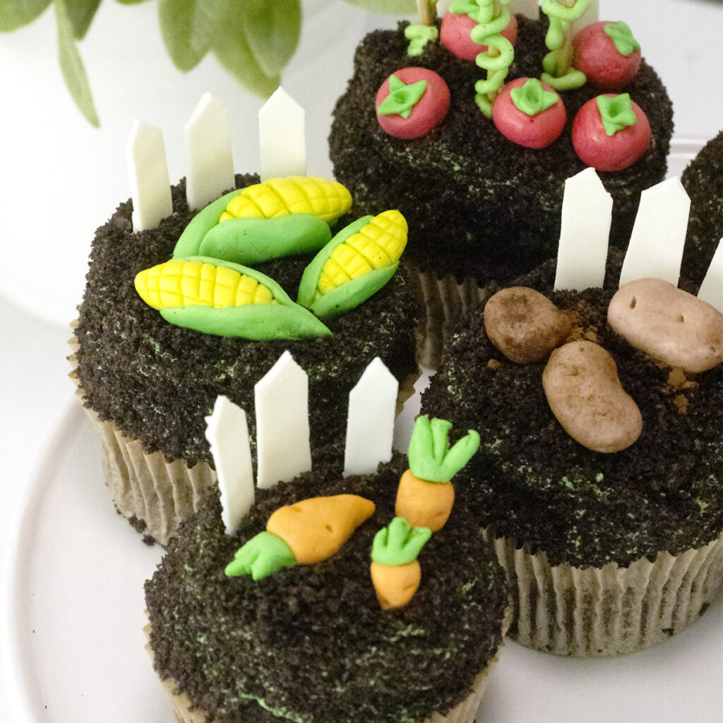 chocolate cupcakes topped with buttercream and modeling chocolate vegetables