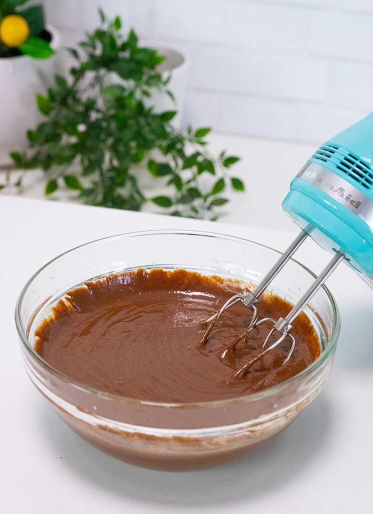 A glass bowl filled with brownie batter.