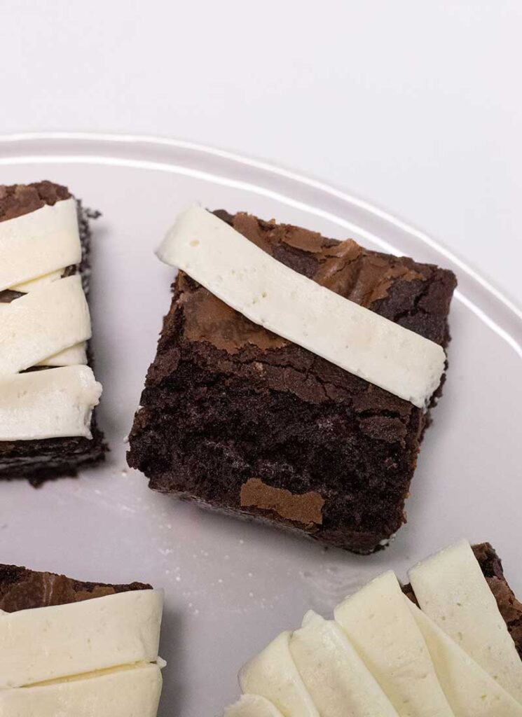 A brownie with one white stripe of buttercream piped on top.