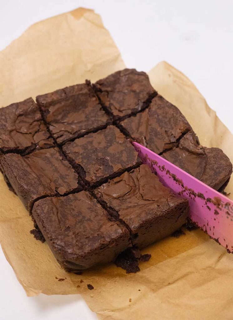 A brownie is being sliced into squares.