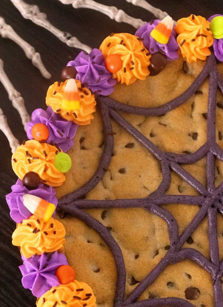 A view of the half of the decorated Halloween cookie. You can see half of the spiderweb pattern, along with the decorative frosting edges.