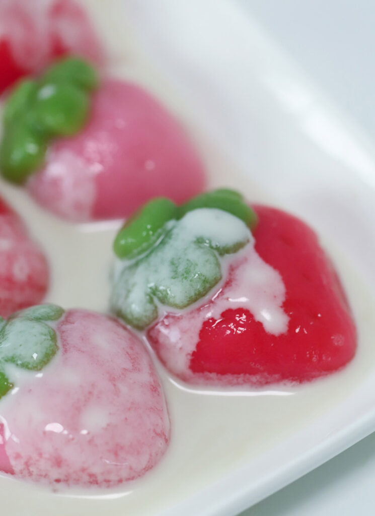 Cream has been poured on top of the strawberry mochi.